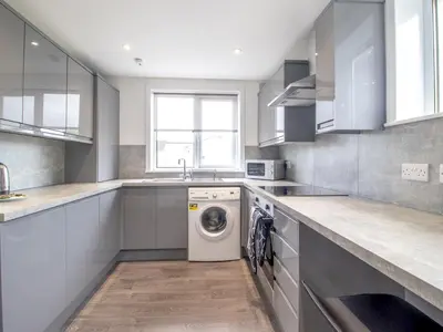 a kitchen with a washing machine and a sink at Renfrew Town Centre Easy Link to Glasgow City - Pass the Keys in Renfrew