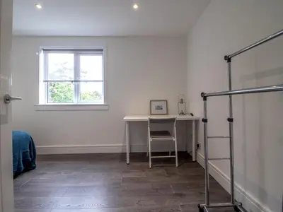 a white room with a desk and a window at Renfrew Town Centre Easy Link to Glasgow City - Pass the Keys in Renfrew