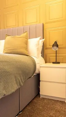 a bedroom with a bed and a nightstand with a lamp at Renton Apartment in Renton