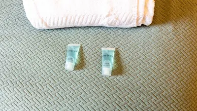two tubes of toothpaste sitting on a carpet at Renton Apartment in Renton