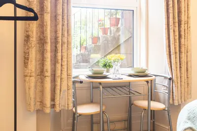 a table and two stools in front of a window at Renton Apartment in Renton