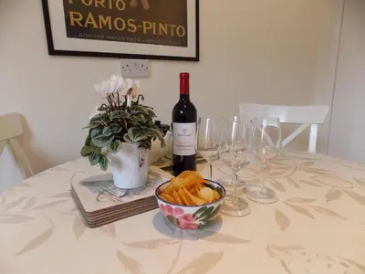 a table with a bottle of wine and a bowl of bread at Violet Bank Apartment Morningside in Edinburgh