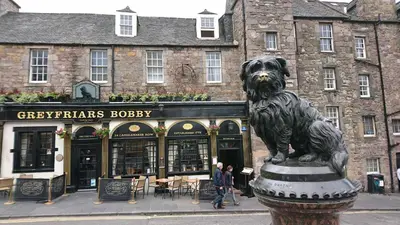 a statue of a dog in front of a building at Violet Bank Apartment Morningside in Edinburgh