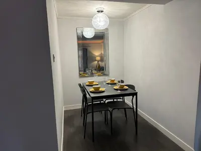 a black dining room table with chairs and a mirror at The Schoolhouse Largs in Largs