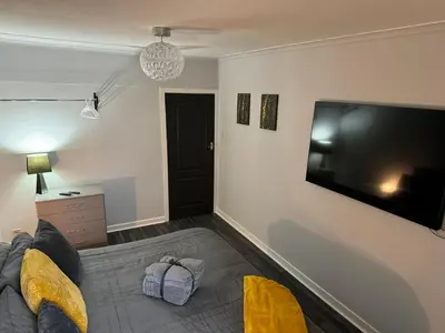 a living room with a large flat screen tv at The Schoolhouse Largs in Largs