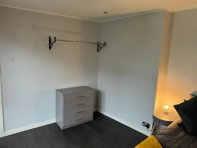 a bedroom with a bed and a dresser in it at The Schoolhouse Largs in Largs