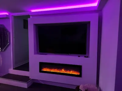 a living room with a fireplace with a tv at The Schoolhouse Largs in Largs