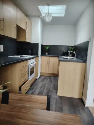 a large kitchen with wooden cabinets and a sink at Bright Edinburgh Flat - City Center EB7 in Edinburgh