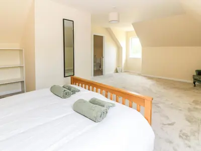 a bedroom with a white bed with two pillows on it at The Barn, Drumbow Farm in Airdrie