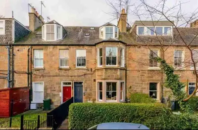 a large brick house with a red door at amazing apartments - Avondale Pl by Stockbridge in Edinburgh