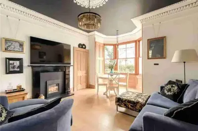 a living room with blue couches and a fireplace at amazing apartments - Avondale Pl by Stockbridge in Edinburgh