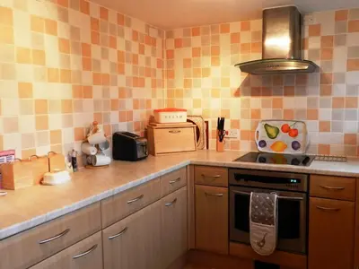 a kitchen with orange and white tiles on the wall at Goatfell View in Brodick