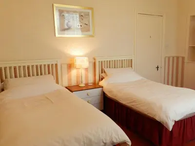 a bedroom with two beds and a lamp on a night stand at Goatfell View in Brodick