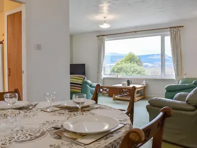 a dining room with a table and chairs and a window at The Willows in Brodick