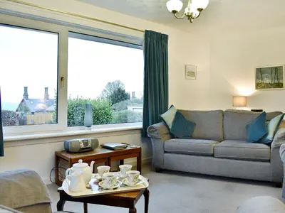 a living room with a couch and a table at Hartholm in Brodick