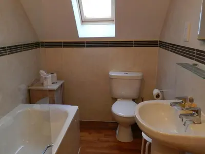 a bathroom with a toilet and a sink and a tub at Seaview Cottage in Lamlash
