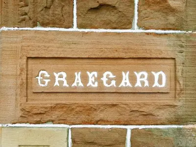 a sign on a brick wall with the wordgralevard at Craegard House in Corrie
