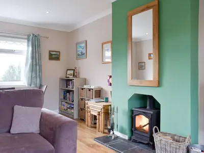 a living room with a couch and a fireplace at Fellview in Brodick