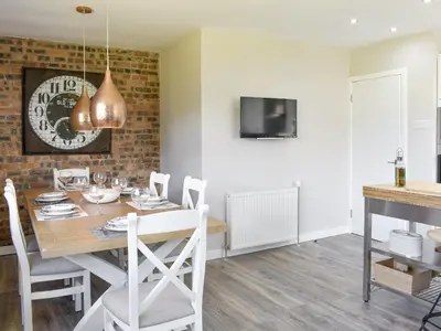 a kitchen and dining room with a table and chairs at Kinneil Land in Lamlash