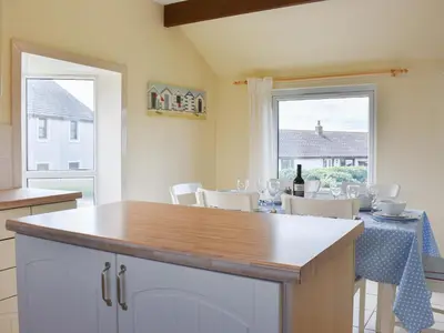 a kitchen with a counter and a table with chairs at Hollinhaven in Blackwaterfoot