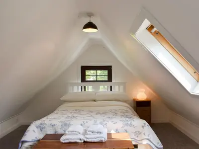 a bedroom with a bed with towels on a table at Ivy Cottage in Whiting Bay