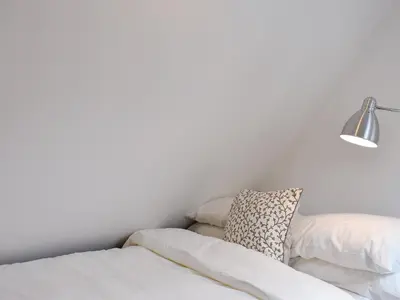 a bed with two pillows and a lamp at Ivy Cottage in Whiting Bay