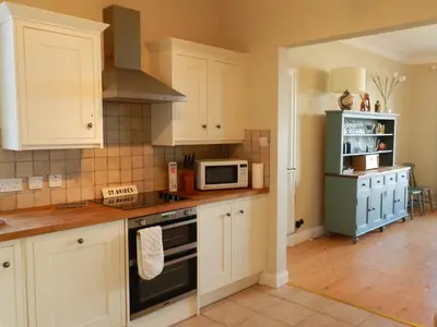 a kitchen with white cabinets and a microwave at St Brides in Lamlash