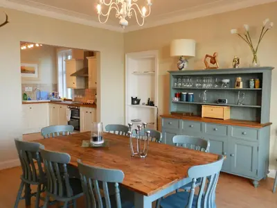 a kitchen with a wooden table and chairs at St Brides in Lamlash