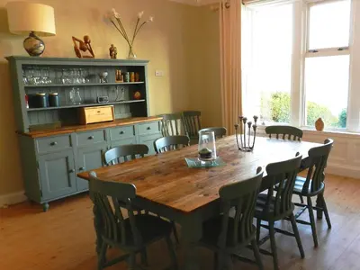 a dining room with a wooden table and chairs at St Brides in Lamlash