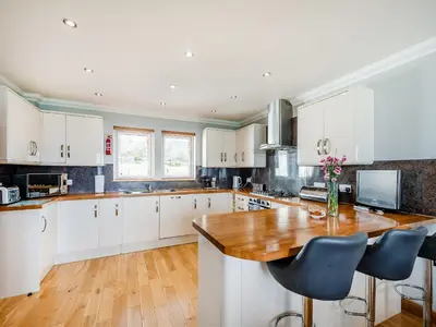 a kitchen with white cabinets and a wooden counter top at Sky View in Ardmaleish