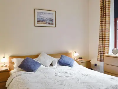 a bedroom with a white bed with blue pillows at Brough Hall in Paisley