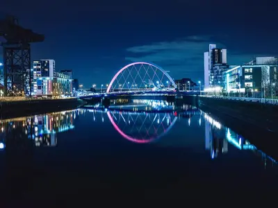 a city skyline with a bridge at night at Brough Hall in Paisley