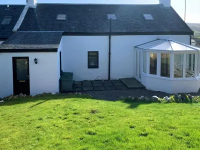a white house with a lawn in front of it at Park House in Blackwaterfoot