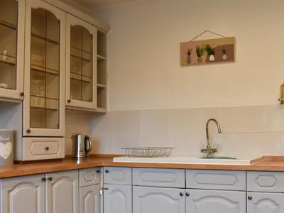 a kitchen with white cabinets and a sink at Park House in Blackwaterfoot