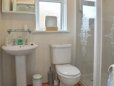 a bathroom with a toilet and a sink and a shower at Redhurst Cottage in Lamlash