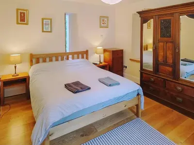 a bedroom with a bed and a dresser and a mirror at Old Steading in Brodick