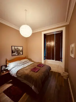 a bedroom with a large bed with a window at Central Room In Historic Tenement Shared Apartment Near Old Town in Edinburgh