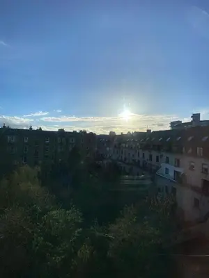 a view of a city with the sun in the sky at Central Room In Historic Tenement Shared Apartment Near Old Town in Edinburgh