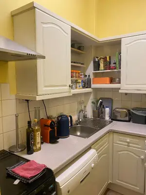 a kitchen with white cabinets and a sink at Central Room In Historic Tenement Shared Apartment Near Old Town in Edinburgh