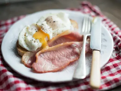 a plate of food with eggs and meat on a table at Wester Auchraw Croft B&B in Lochearnhead