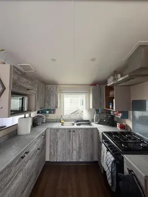 a large kitchen with a sink and a stove at 23 Chestnut Grove in Kirkcolm
