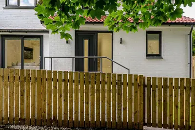 a wooden fence in front of a house at Wyndford Riverside House in Glasgow
