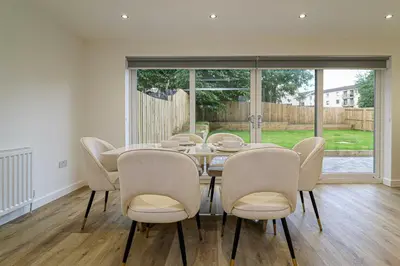a dining room with a table and chairs at Wyndford Riverside House in Glasgow