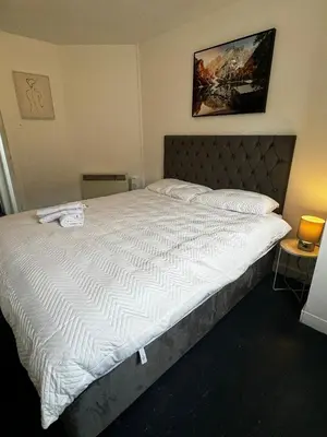 a bedroom with a large bed with white sheets at Victoria Street View Flat in Edinburgh EB10 in Edinburgh