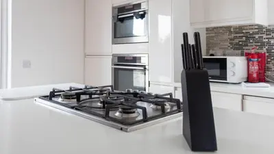 a kitchen with a stove top oven and a microwave at Moncrieff House in Livingston