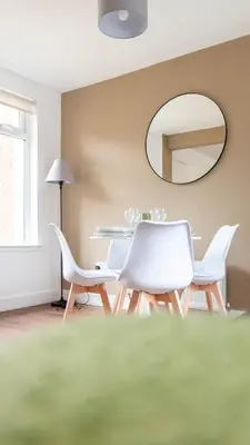 a dining room with a table and chairs and a mirror at Moncrieff House in Livingston