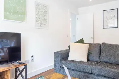 a living room with a couch and a tv at Moncrieff House in Livingston