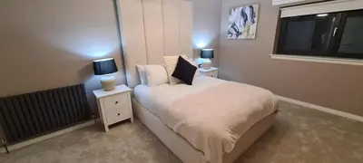 a bedroom with a bed with two night stands and two lamps at The Old Courthouse in Rothesay
