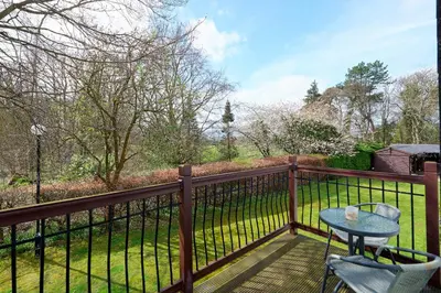 a balcony with a table and chairs on a fence at Brig O'Doon 1 in Ayr