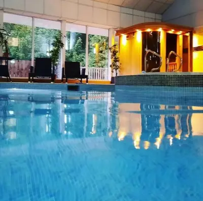a large swimming pool with blue water at House in Drymen Village with free local health club access in Glasgow